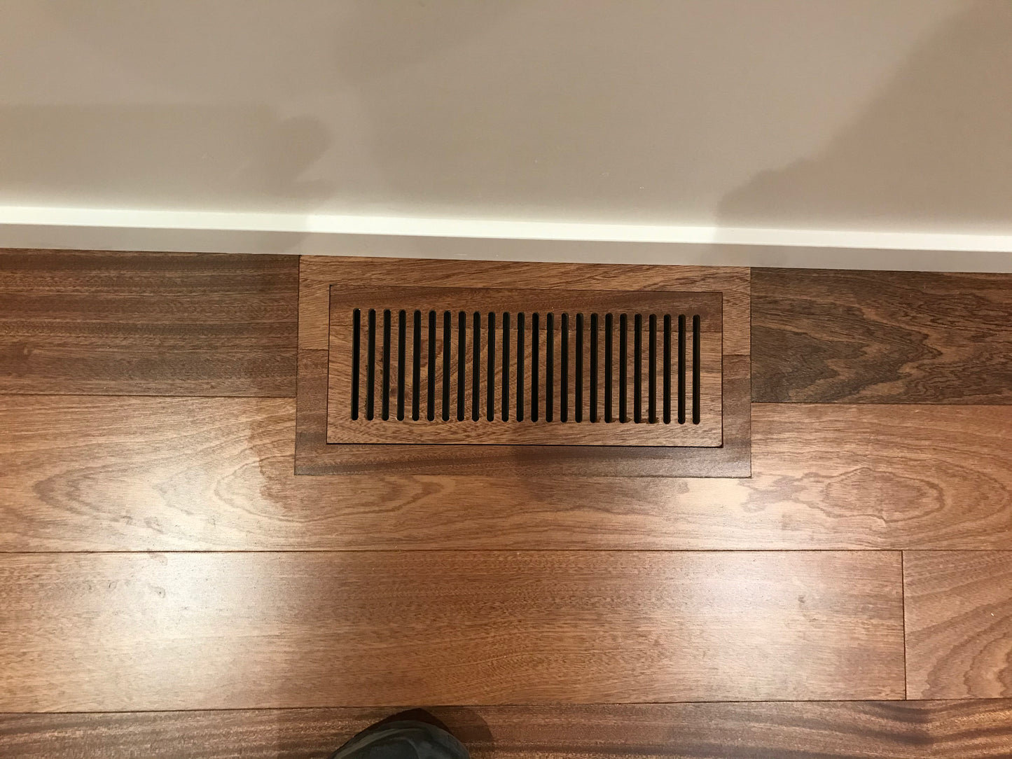 Close-up view of custom-engineered hardwood floor vent, designed for a flush fit with high-quality hardwood flooring.