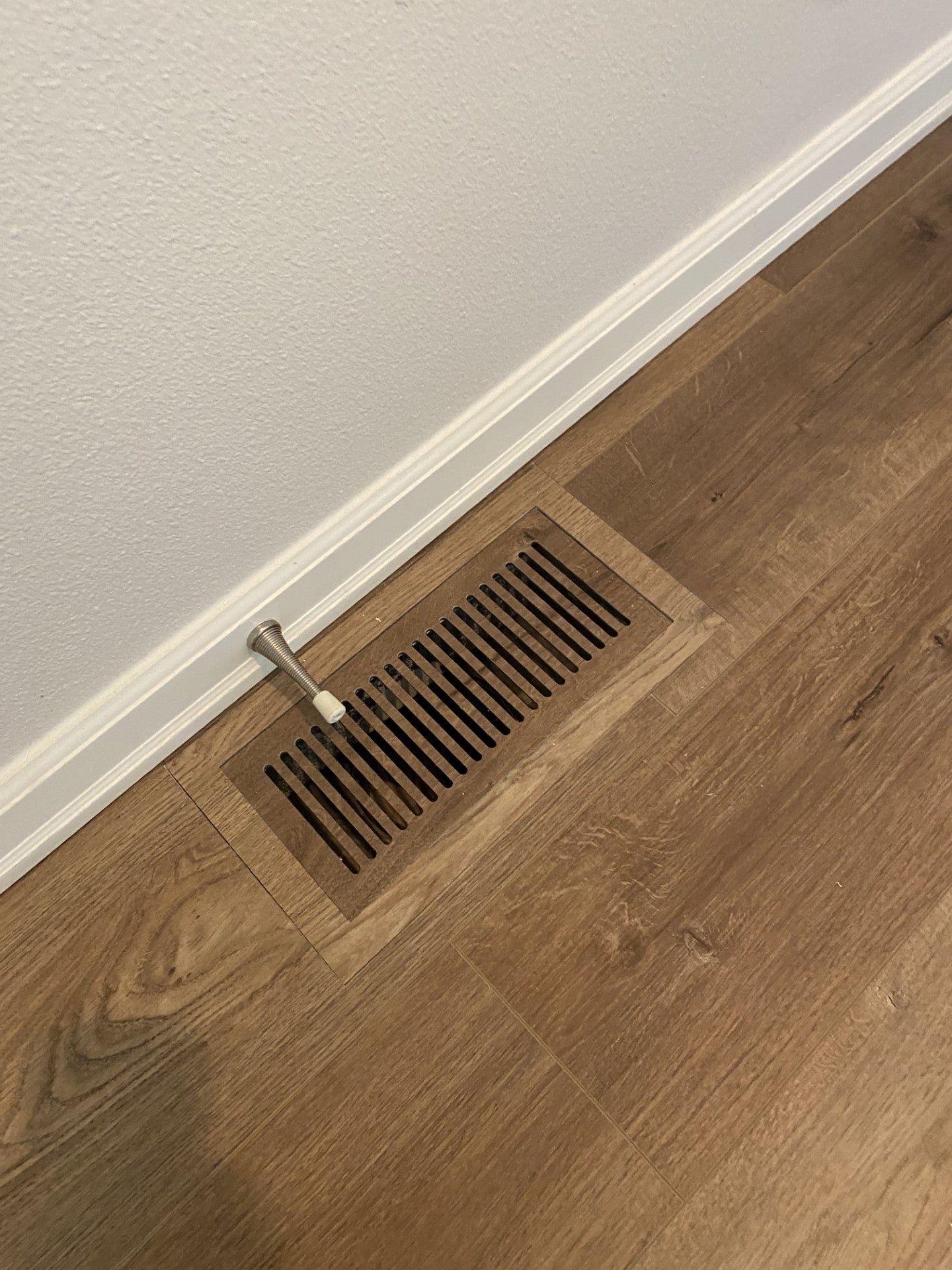 Custom floor vent seamlessly installed in engineered hardwood floors, providing both style and functionality.