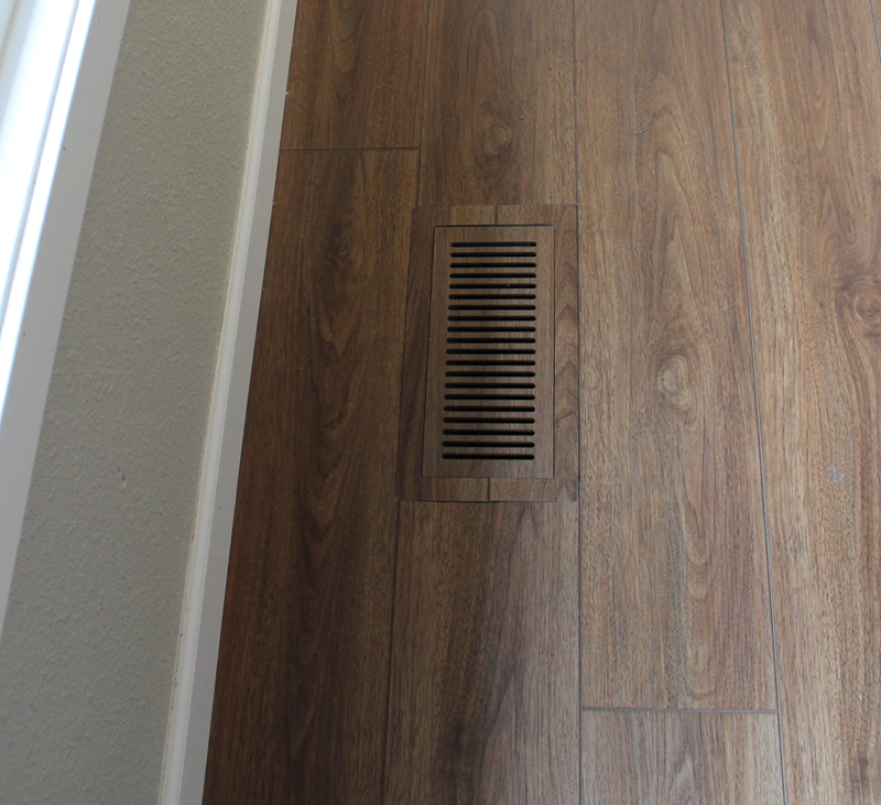 Vents.com vent blending into a dark wood-look floor